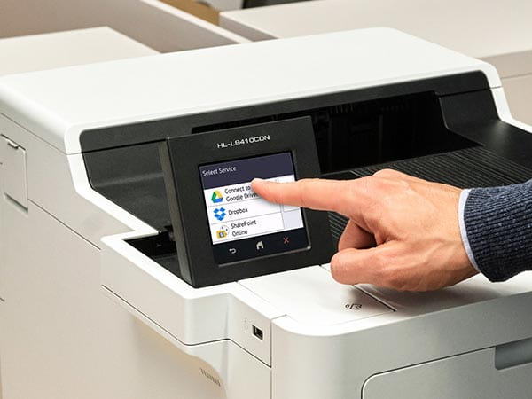 Person using printer's touchscreen to select print-from location: Google Drive, Dropbox, or Sharepoint