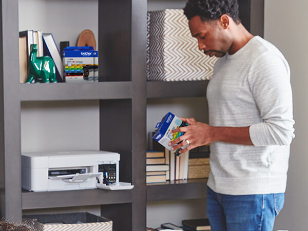 Man opening a Brother Genuine LC404 ink cartridge for printer