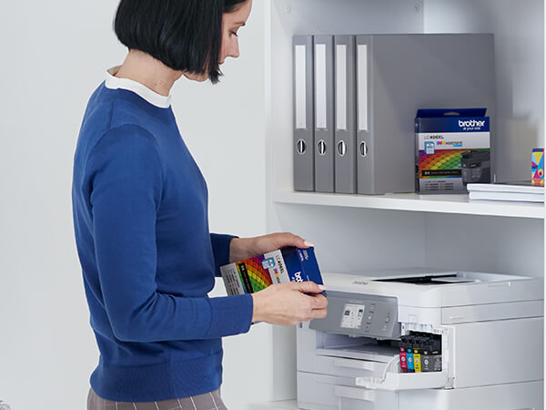 Person inserting new Brother Genuine LC404 ink cartridge into printer