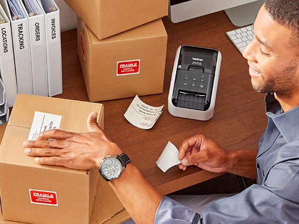 Man in office printing black on white address labels