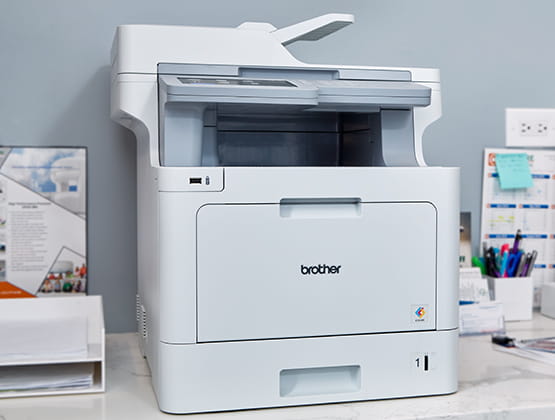 MFC-L9570CDW on a desk in office space