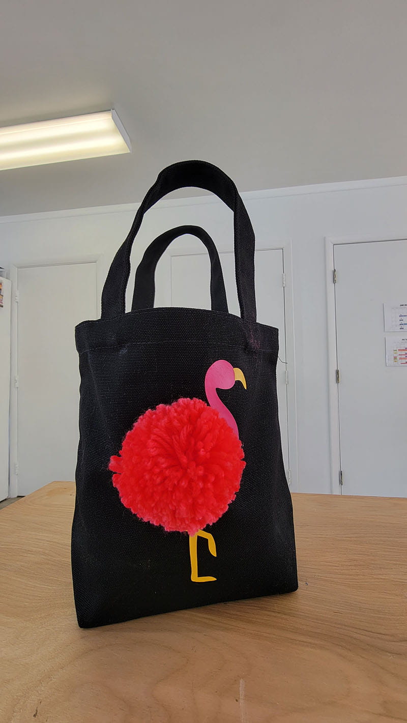 Completed flamingo tote on a wooden desk