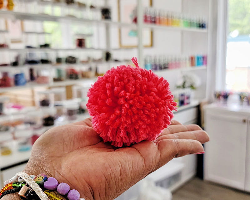 Pink pom pom in a womans hand.