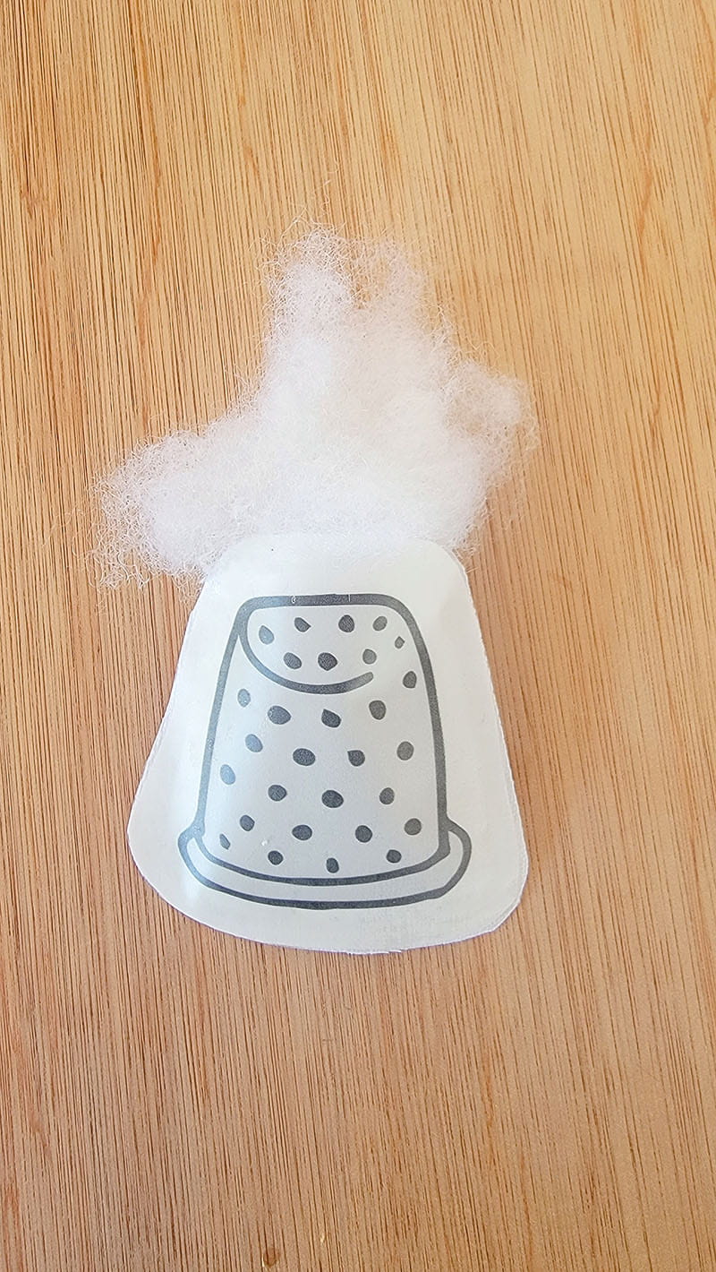 filling the printed and adhered fabric with cotton filling to give the ornaments their plush appearance