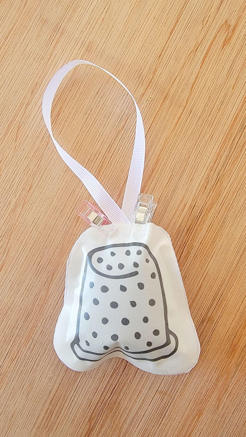 Plush ornament being held by fabric clips while allowing the glue to dry