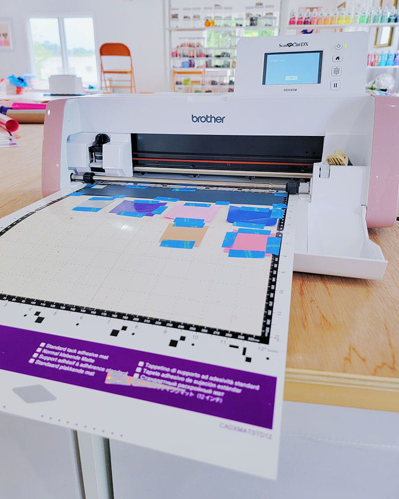 Vinyl scraps on ScanNCut mat being fed through Brother ScanNCut cutting machine