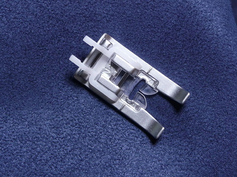 Head for a sewing machine on blue fabric