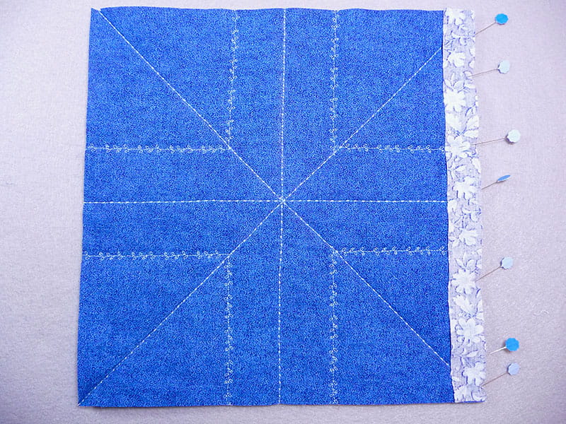 top view of the fabric and the edge pieces with pins holding them where they need to be stiched