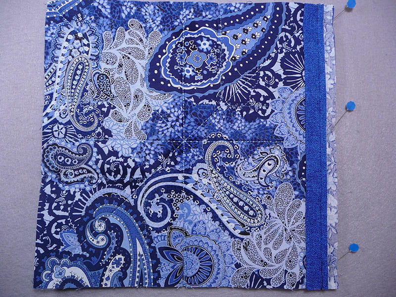 fabric with pins displaying where it needs to be sewed together
