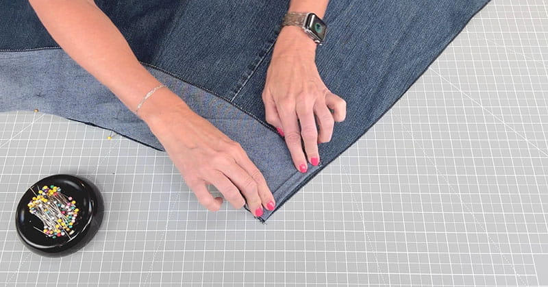 Folding the fabric over and holding it down with pins