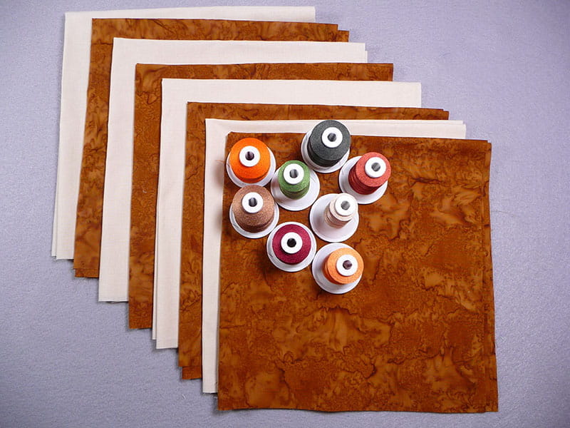 Napkins alternating with marble pattern and cream with embroidery thread on top. 