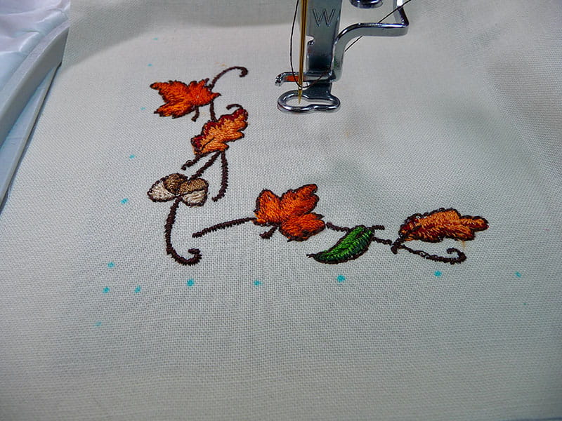 Leaf embroidery design on cream napkin in embroidery hoop.  