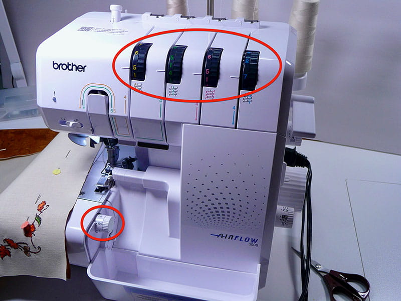 Airflow 3000 air serger machine with leaf embroidery napkin on side. 