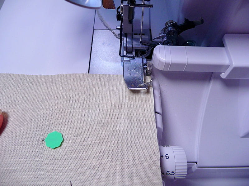 Napkin sitting in Air Serger machine to begin finishing stitch.