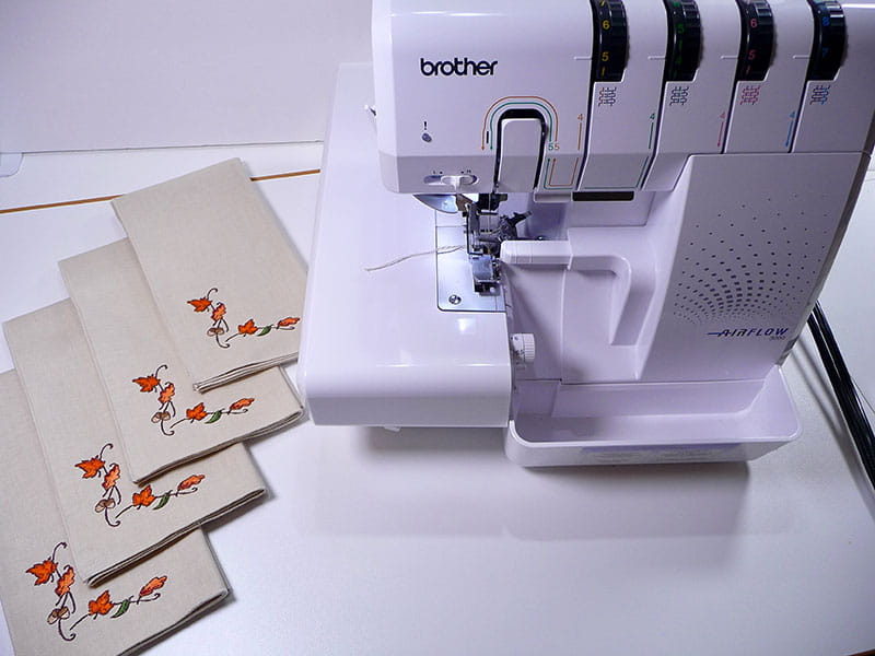 Airflow 3000 air serger with folded leaf embroidered napkins to the left.