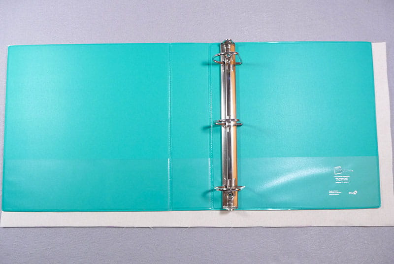 Aqua binder with notebook cover behind.