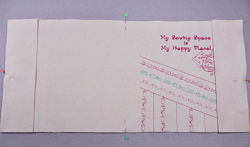 My sewing space is my happy place embroidered notebook cover with additional fabric pinned down on left and right sides