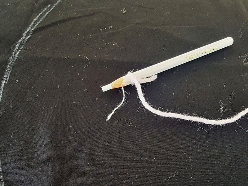 Pen with thread attached to cap