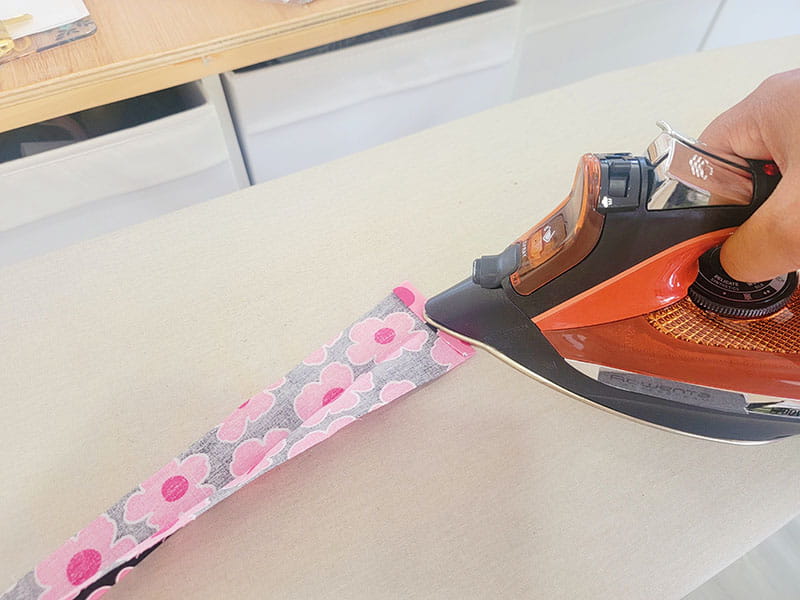 Ironing the fabric to keep it from opening up