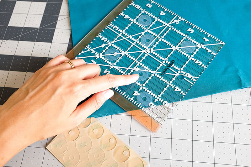 Person using ruler with angles on teal fabric