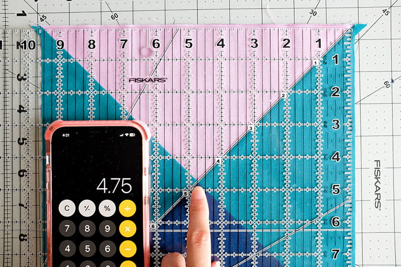 Zoomed in images of person holding quilting ruler on top of fabric to find center point of quarter square triangles.