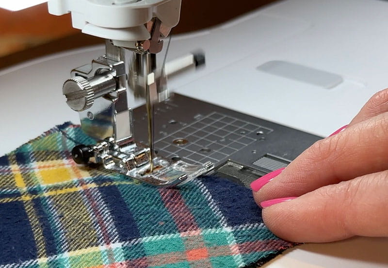 hand sewing the edges of brims while holding the cloth
