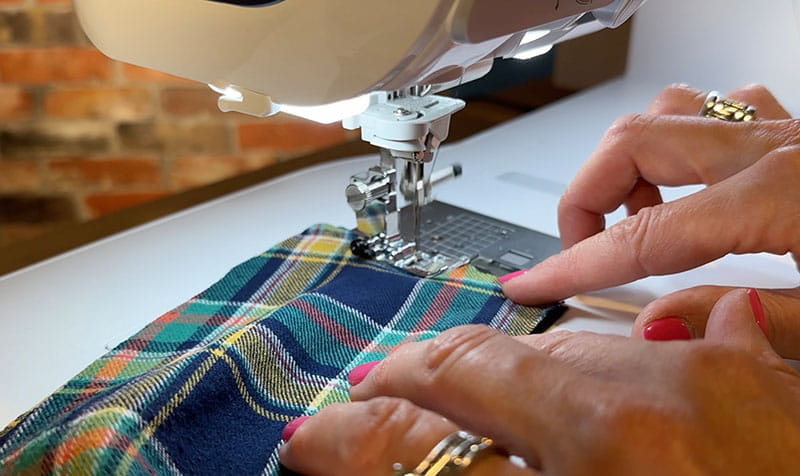 hands sewing ends of middle pieces of the flannel