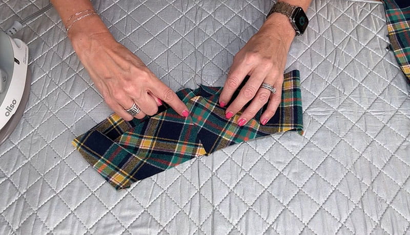 hands holding cloth in white background displaying the colors of the flannel shirt
