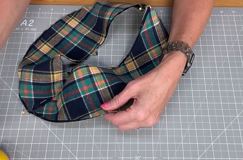 hand holding cloth while using pins in the edges to hold them together