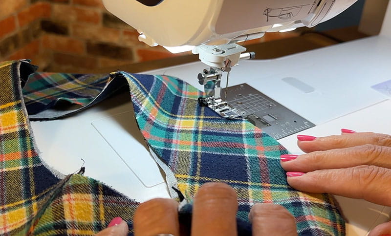 stitching around the brim to the top of the flannel cloth, hands holding the cloth