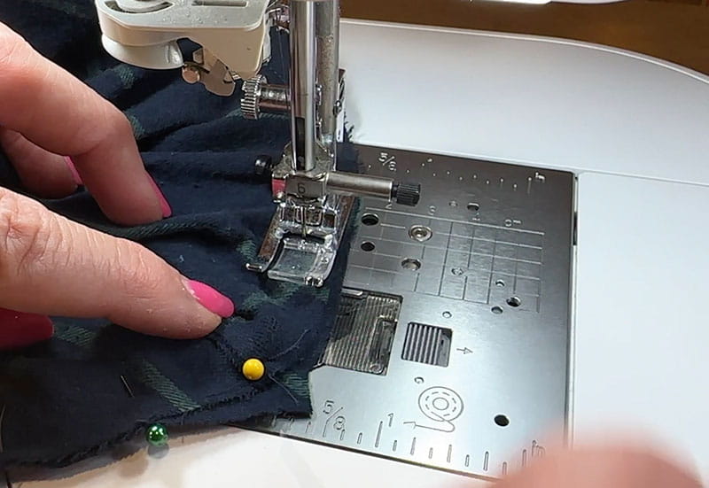 Sewing machine sewing around black fabric