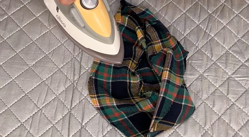 yellow iron pressing on the opening of the bucket hat