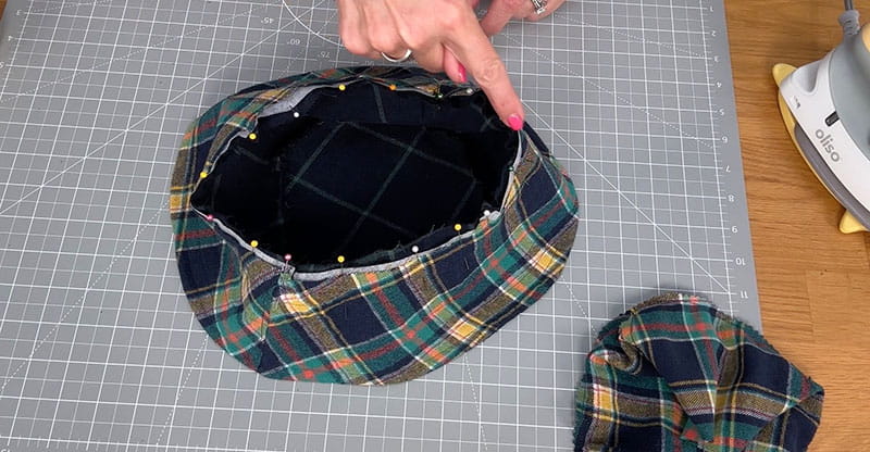 hand pointing at pins on the brim of the bucket hat