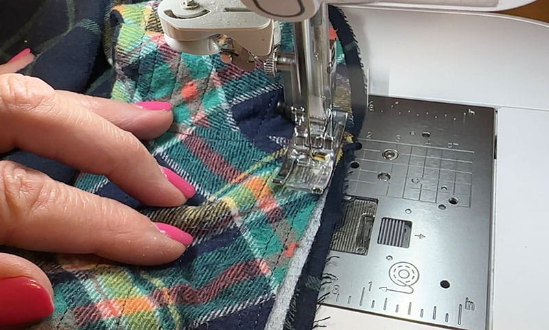hands sewing the brim of the bucket hat to the inner middle section