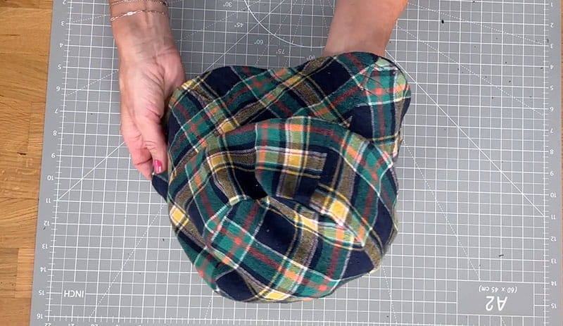 Hands holding bucket hat top view grid background