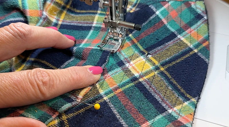 hands moving the bucket hat into the sewing machine