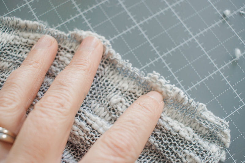 Stretching the knit out to show details of the fabric