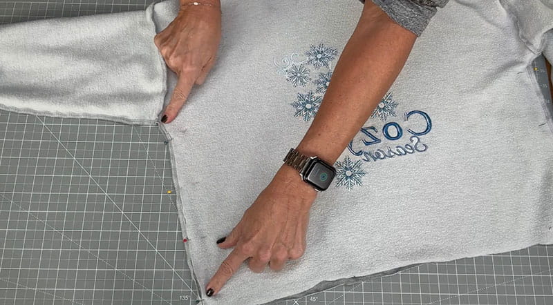 Grey sweatshirt laid on top of cutting board mat