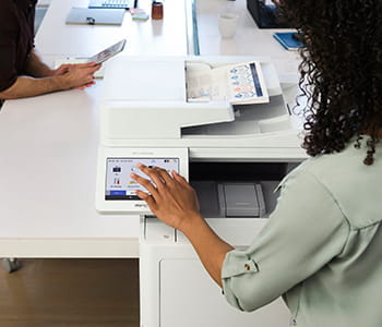 Woman using Brother MFC-L9670 enterprise laser printer in office