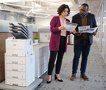 Co-workers standing in front of Brother printer
