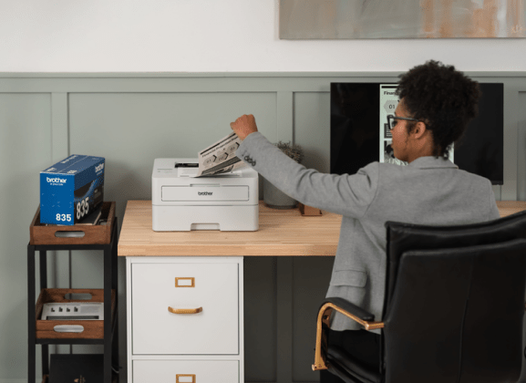 Person Taking Paper from Brother Printer