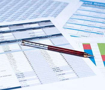 Pen on data sheets showing sales figures