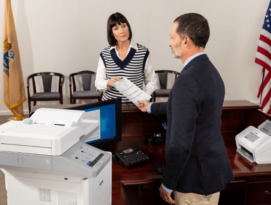 Man Holding Paper out Brother Printer in a Government Office