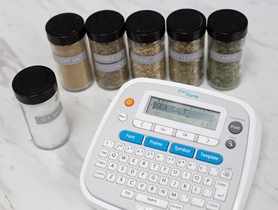 A variety of spices laying on countertop together with Brother Ptouch Label maker