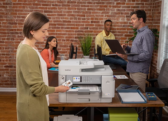Woman in office setting printing documents securely using badge on a Brother MFC-J5955DW all-in-one