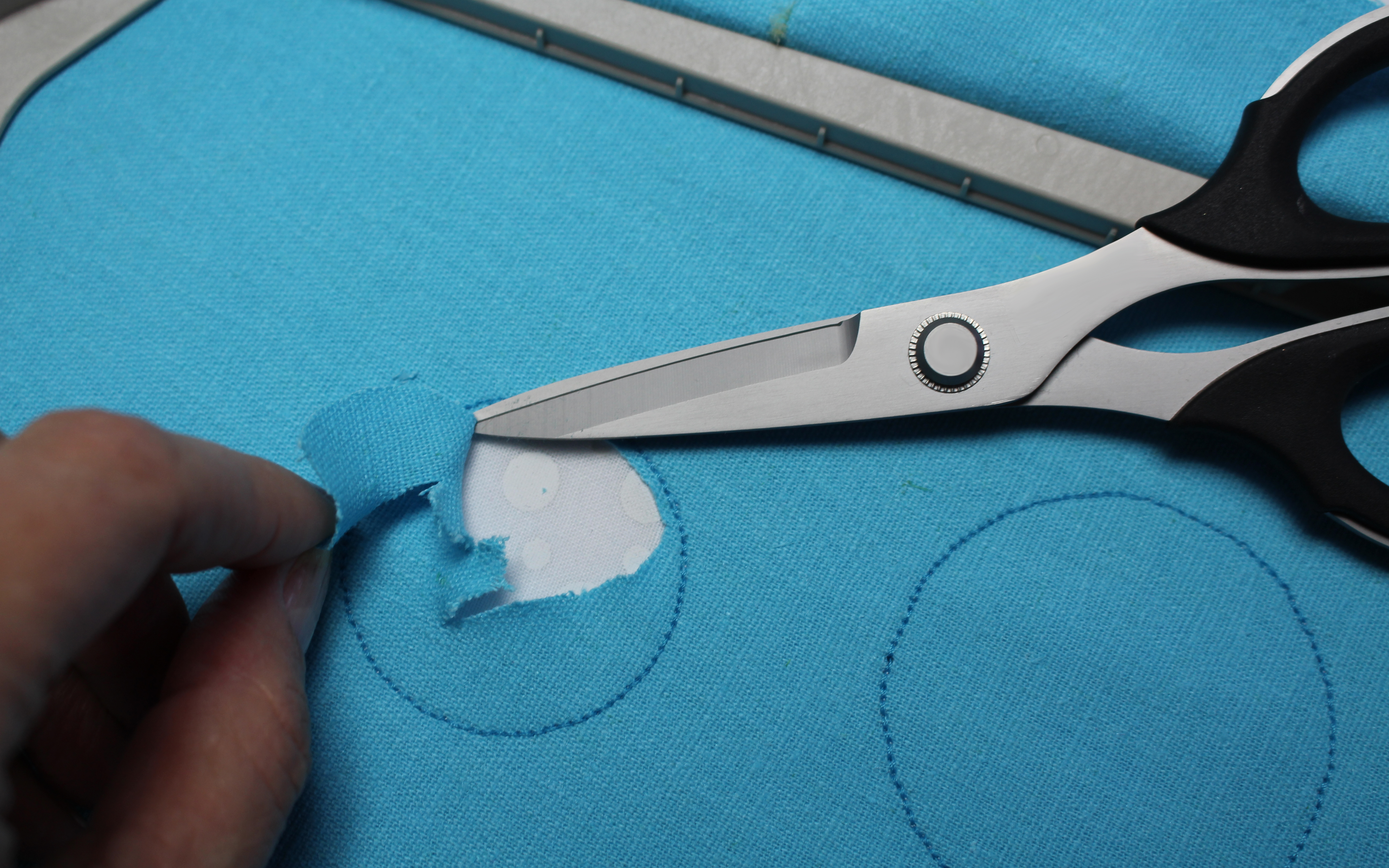 Don't unhoop. Trim fabric inside circles.